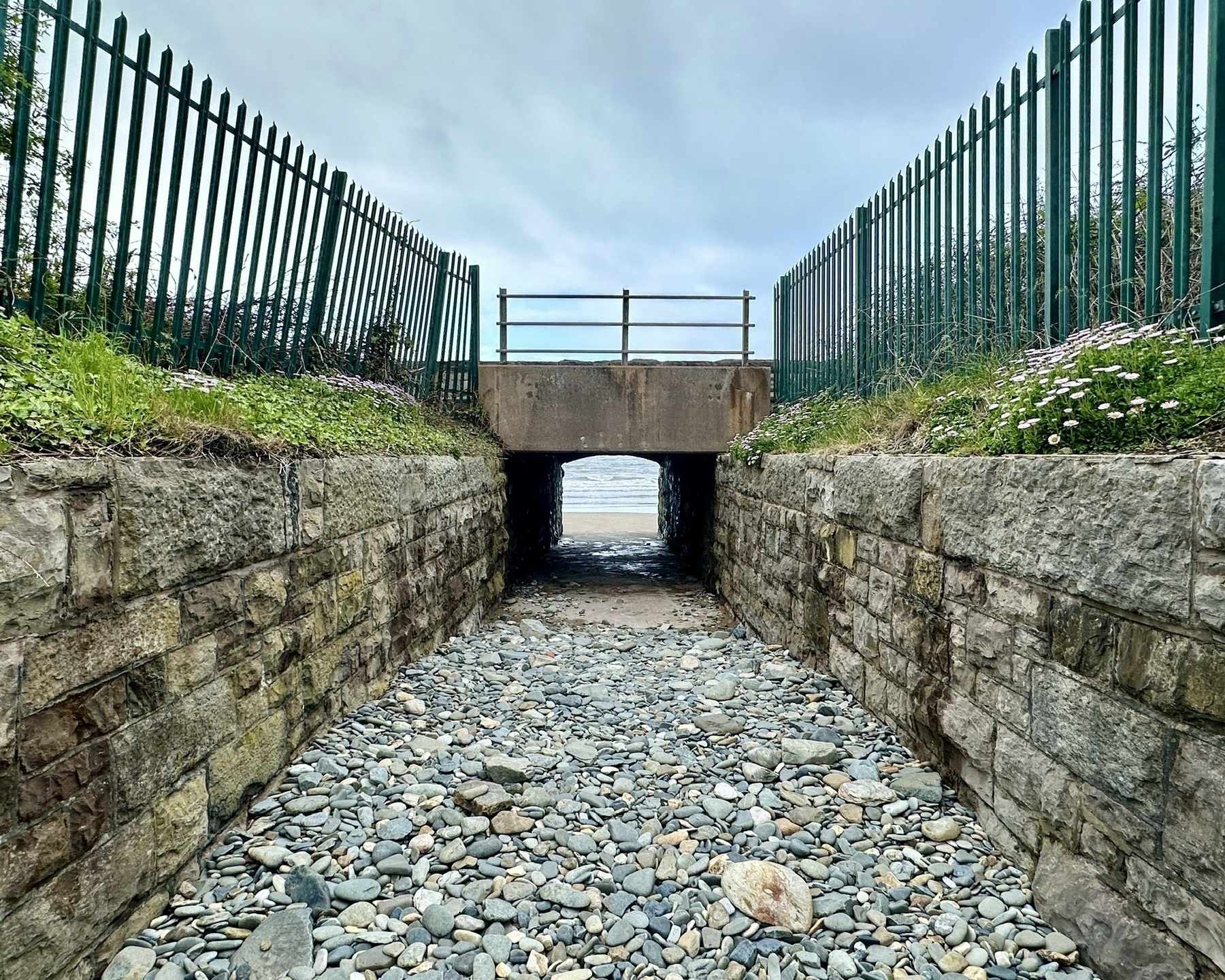 a tunnel that leads to a small secluded beach